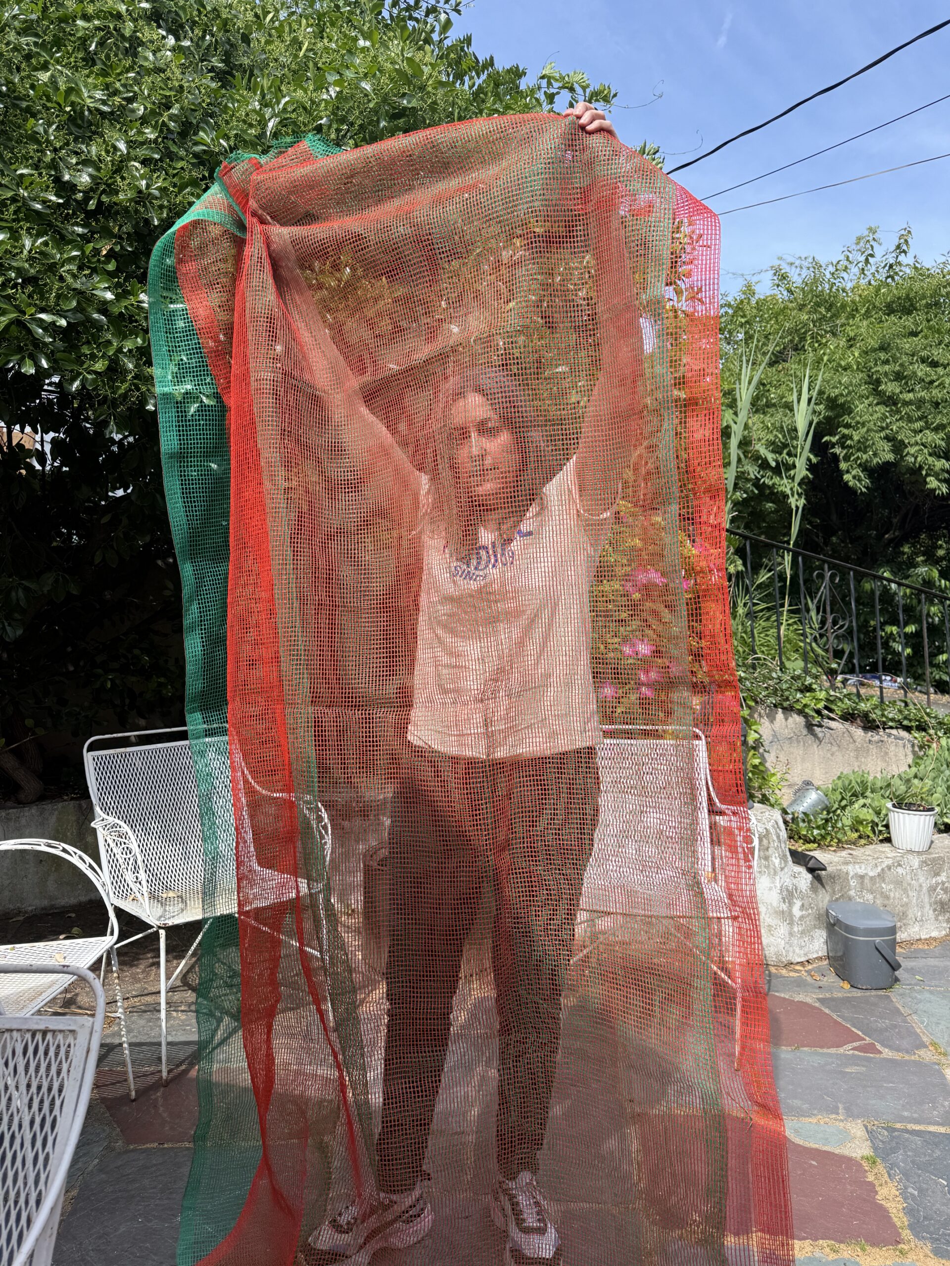 Green and orange netting panel held up demonstrating layering and dimensions.