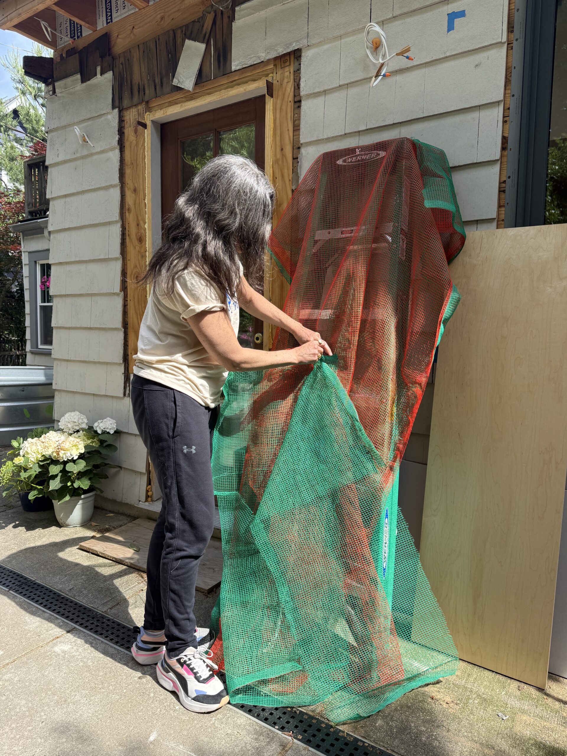 Green and orange netting panel held up demonstrating layering and dimensions.