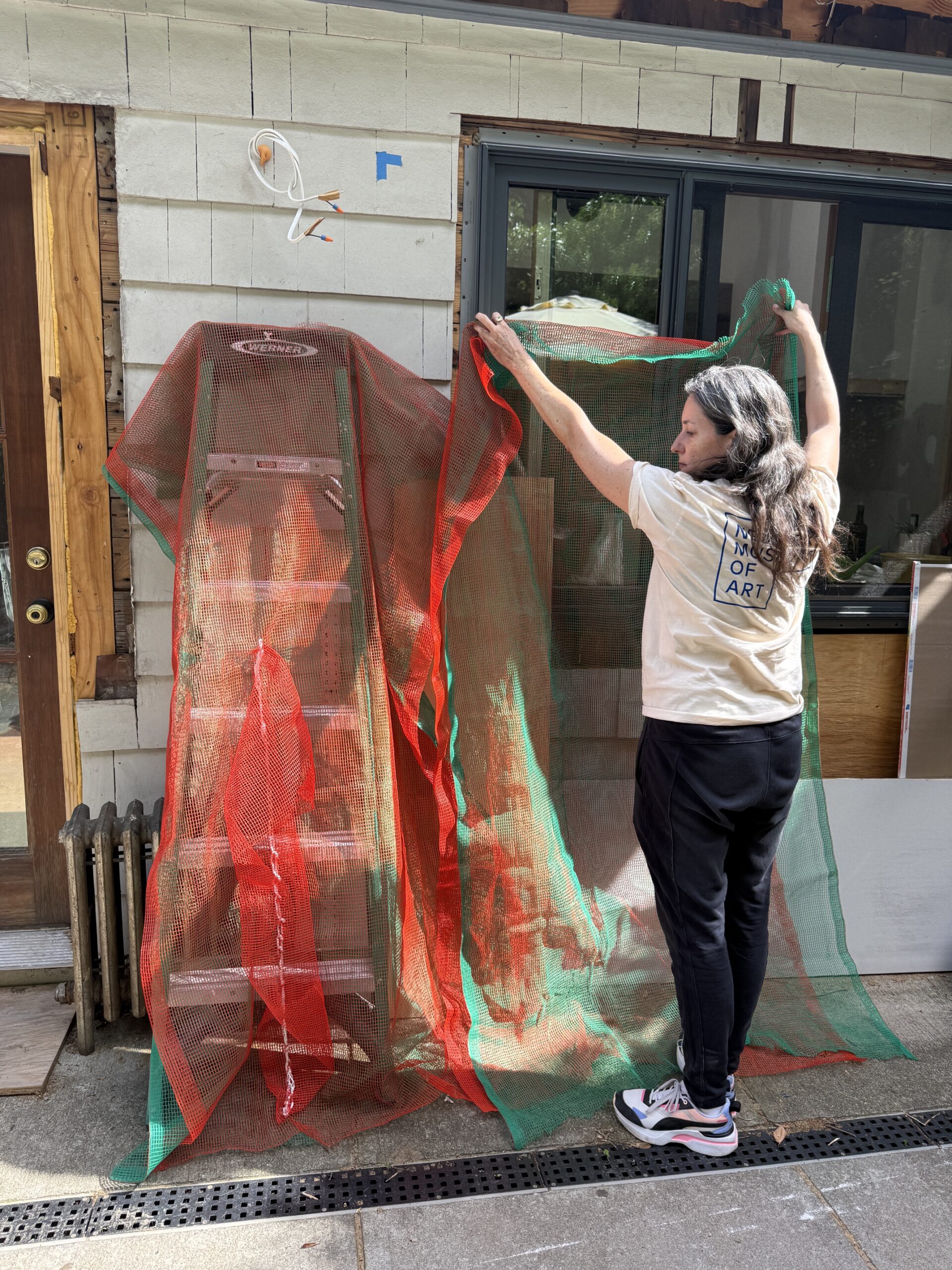 Green and orange netting panel held up demonstrating layering and dimensions.